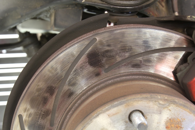 The bluish hot spots on this rotor likely caused by inconsistent transfer of material between the pad the rotor. These were probably created when the pads were not properly bed in. You might be able to see this rotor is also suffering from surface stress cracks. This rotor should be replaced.