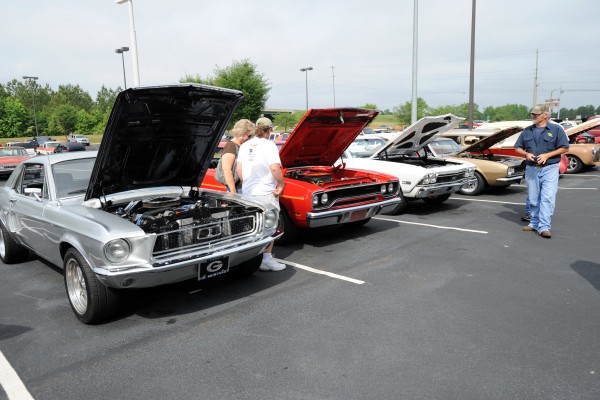 row of vintage musclecars at a car show