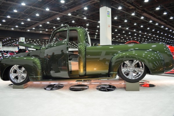 lowered green show truck on display at a indoor car show