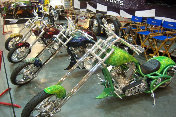 row of custom motorcycles at indoor car show