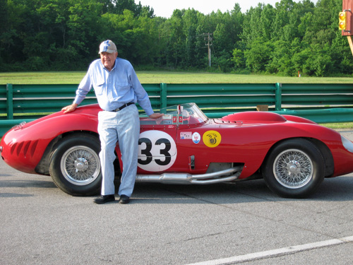 carrol shelby poses against red race car