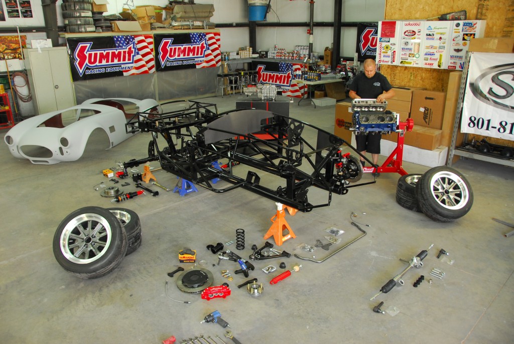 cobra kit car disassembled with parts laid out on floor