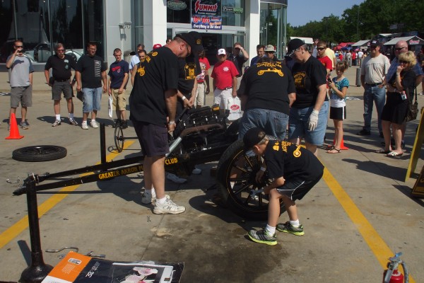 men assembling a ford model t demonstration, fitting front wheel