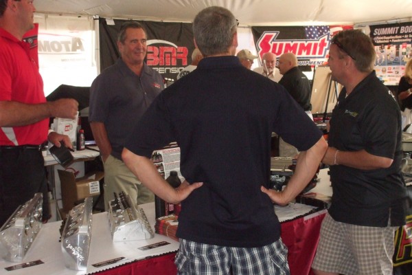 men talking at an automotive trade show display