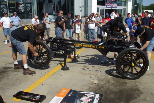 men assembling a ford model t demonstration, rear wheels