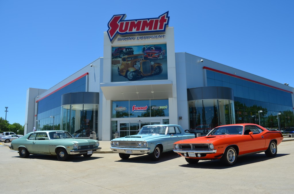 a group of classic cars parked in front of summit racing