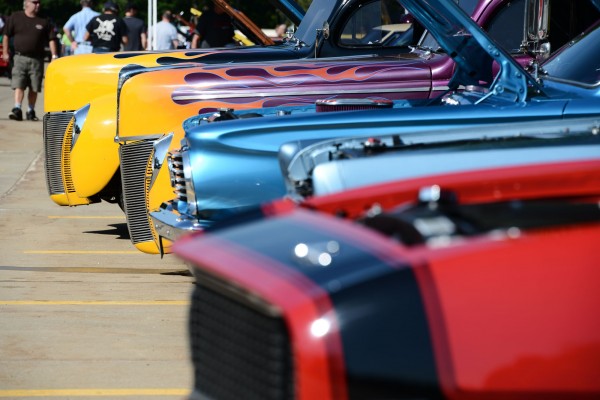 row of classic vehicles at a vintage car show
