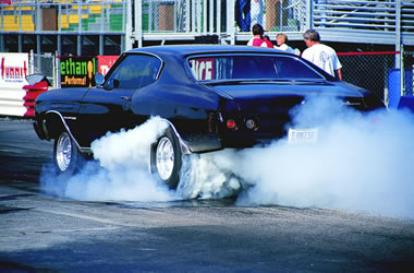 muscle car doing a burnout at the track