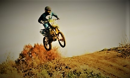 rider leaping a dirt bike over a hill