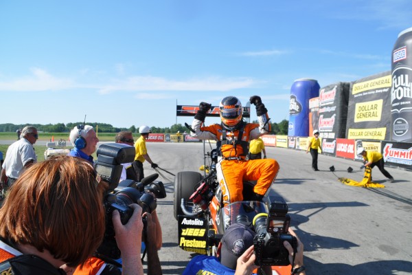 nhra driver cheering after a drag race victory