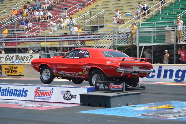 vintage dodge challenger race car doing a wheelstand at launch