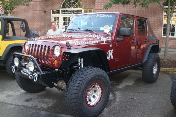 Maroon lifted Jeep Wrangler with off road tires