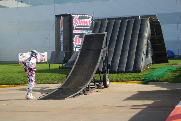 dirt bike rider setting up ramp for an aerial leap