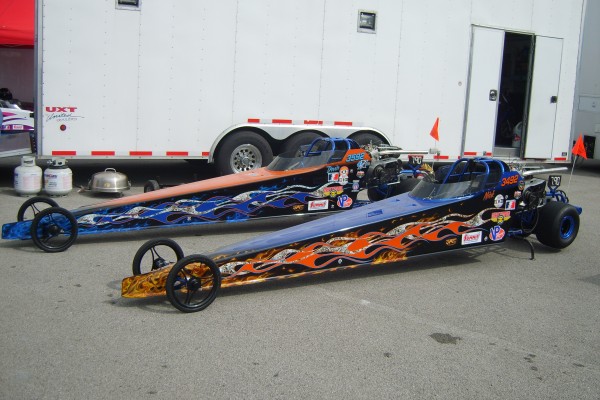 a pair of dragsters in pits prior to a race