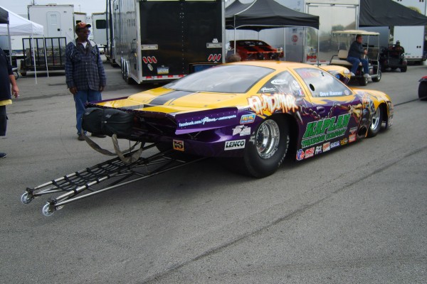 pro stock race car moving to staging lanes in pits