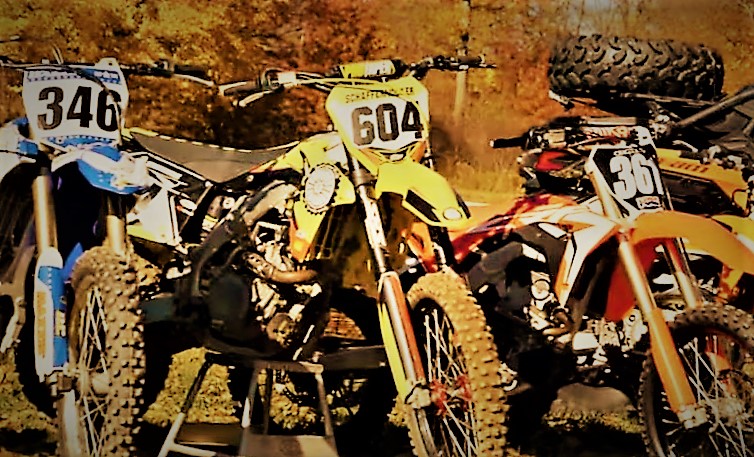 row of dirt bikes parked outside