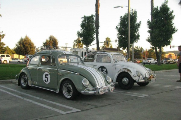 a pair of vintage Volkswagen Beetles in a parking lot