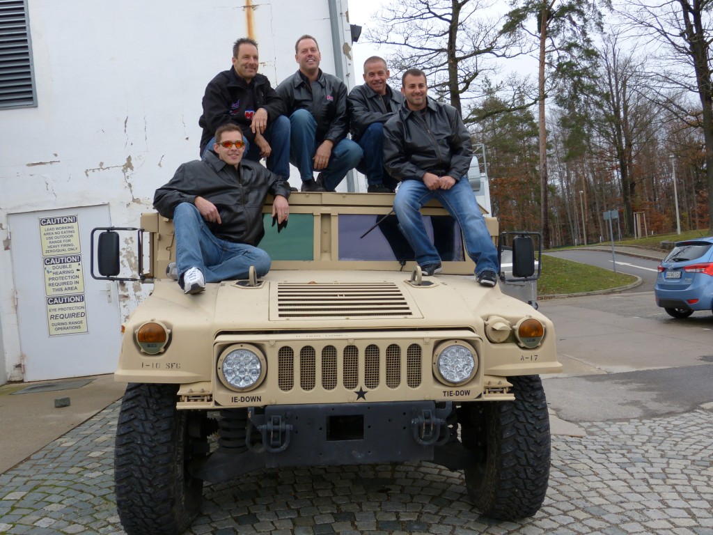 NHRA drivers pose for picture on top of a military humvee
