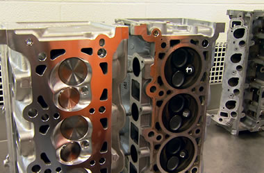 a pair of ford modular v8 cylinder heads on a workbench