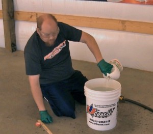 man cleaning the floor of a large garage shop
