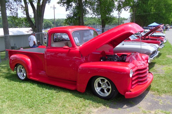 row of vintage cars and trucks at a classic car show