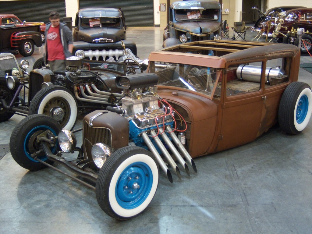 rat rod with v8 engine and blue wheels