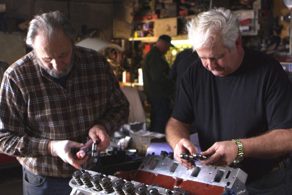 two men working on assembling a v8 engine