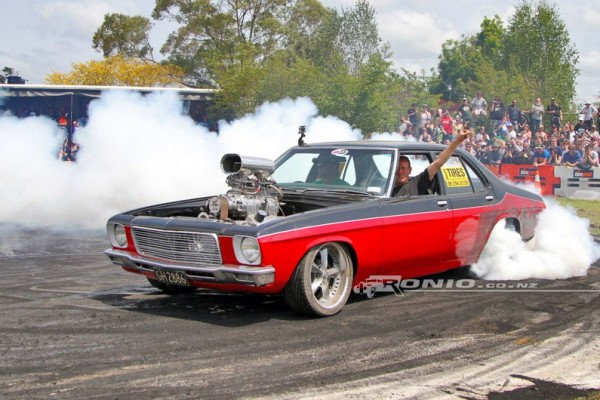 man doing a burnout in a vintage muscle car