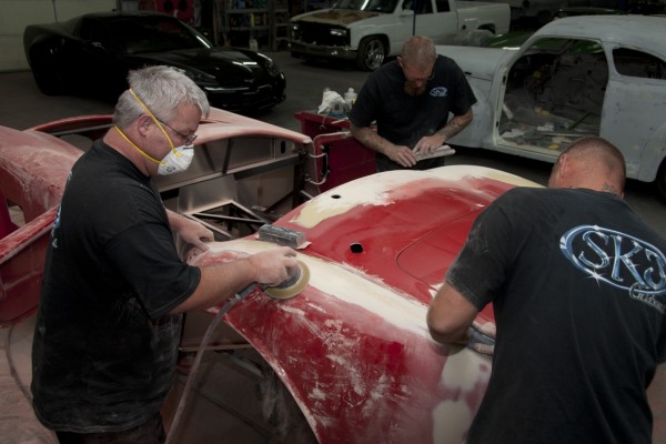 men applying filler and sanding bodywork on a cobra kit car