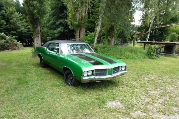 green and black Oldsmobile cutlass coupe