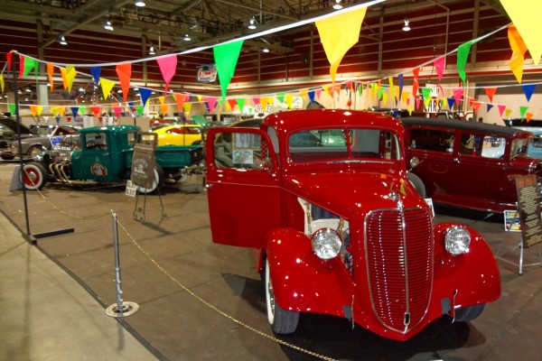 vintage cars and trucks at an indoor classic car show