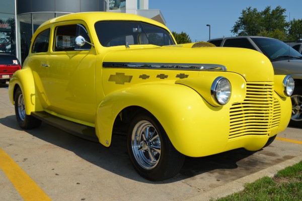 Yellow chevy prewar hot rod coupe in a parking lot