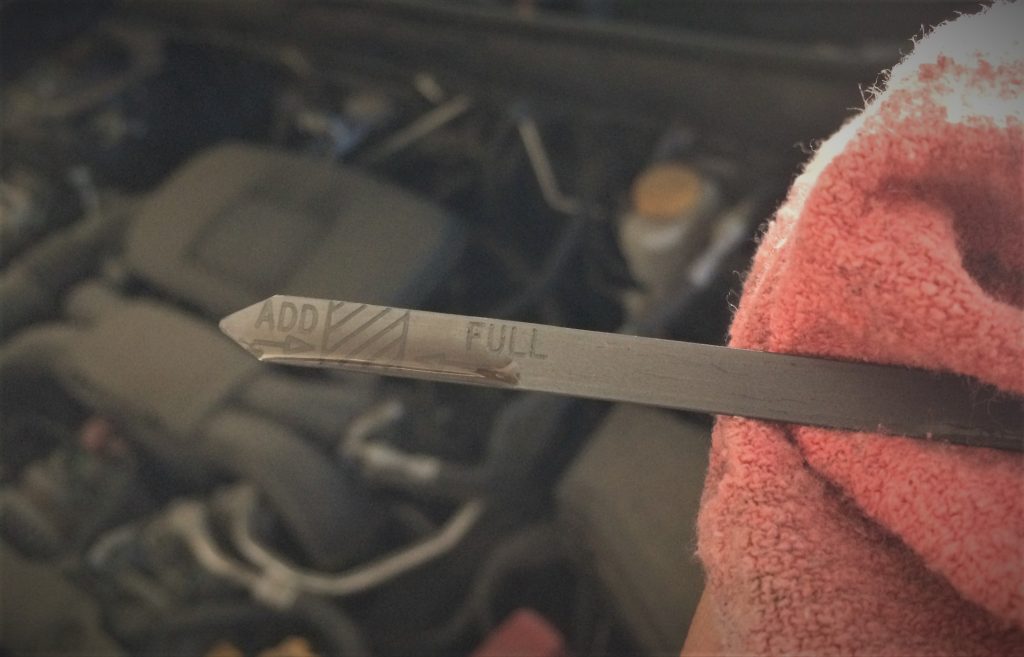 engine oil on dipstick with rag to check oil level