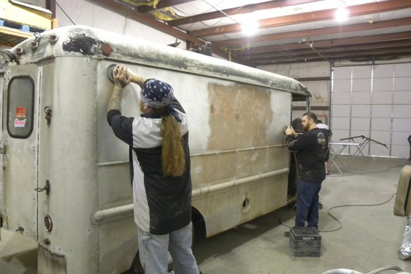 men working on surface prep on a vintage chevy delivery truck body