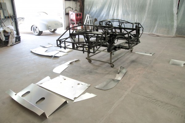 car chassis with aluminum body panels placed nearby