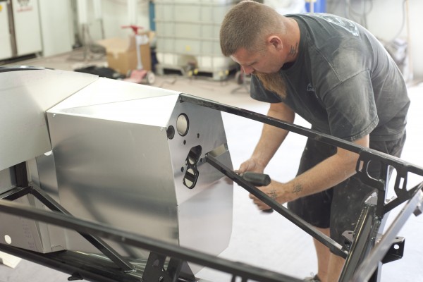 man assembling kit car body panels