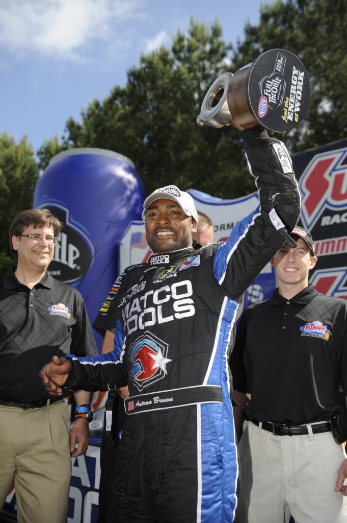 NHRA Top Fuel Driver Antron Brown lifting a Wally Trophy, 2013