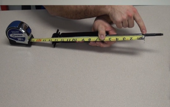 man measuring a shock absorber