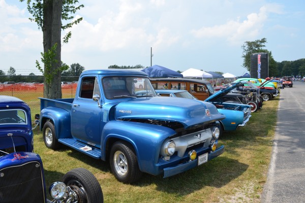 row of vintage cars at a big outdoor car show