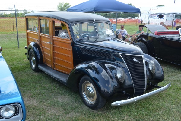 a vintage woody wagon hot rod at a car show