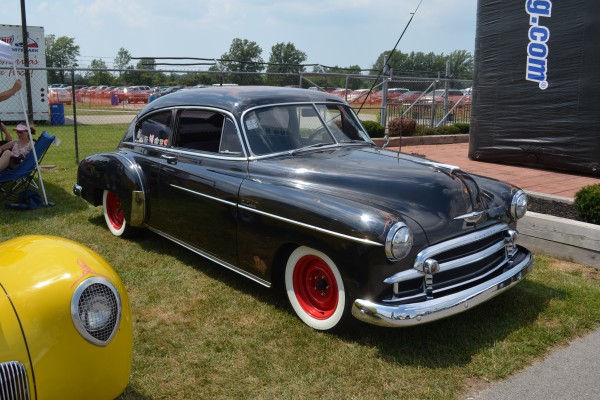 black hot rod coupe with red wheels and whitewalls