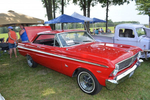 a red ford falcon v8 muscle car at a show