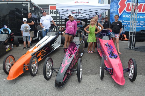 Children posing for pictures next to their Jr. Dragster race cars