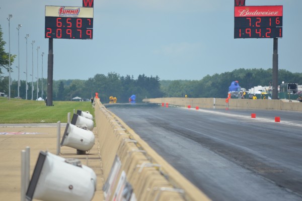end of a drag race track, 2 dragster in distance with scoreboards