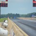 end of a drag race track, 2 dragster in distance with scoreboards thumbnail