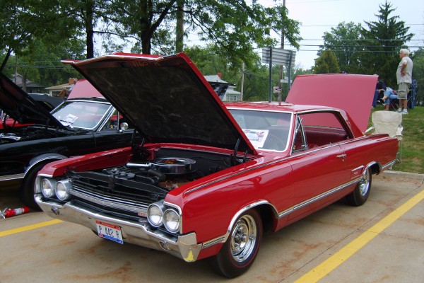 a 1965 red Oldsmobile cutlass hardtop coupe