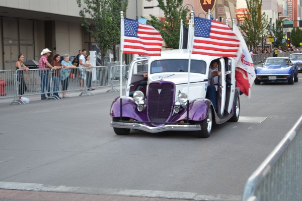 custom hot rod carrying flags in parade at Hot August Nights 2013