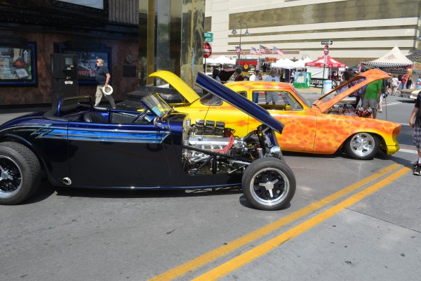 pair of hot rods on street during a classic car cruise in