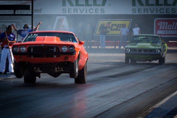 a dodge challenger drag car launching during a drag race