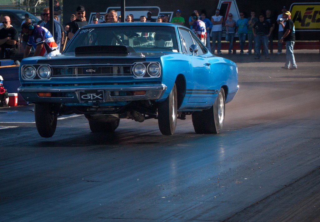 vintage plymouth gtx launching at a drag race